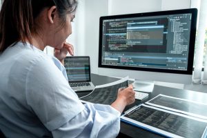 female developer programer working on coding software computer writing