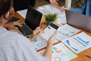 Businesswoman,Using,A,Calculator,To,Calculate,Numbers,On,A,Company's