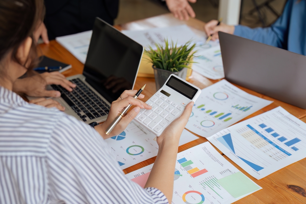 Businesswoman,Using,A,Calculator,To,Calculate,Numbers,On,A,Company's
