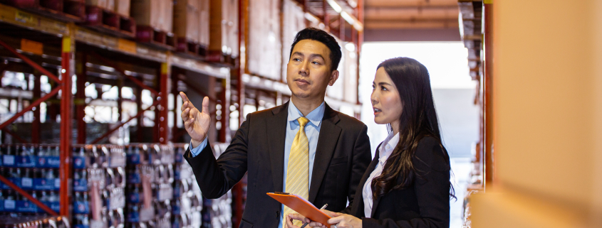 Asian two business people discussing of product at storage wareh