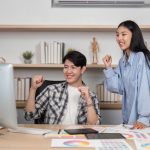 Hiring Offshore Freelancers in AU vs PH: 7 Legal Differences Joyful Designers in UX and UI. Two colleagues celebrate their success with excitement in a modern office.