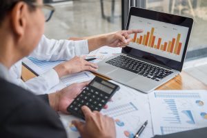 man in office with laptop and graphs