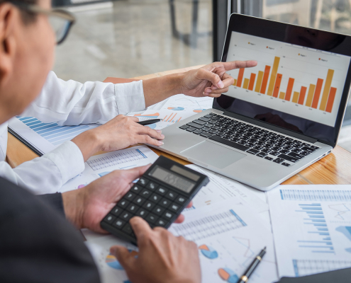 man in office with laptop and graphs