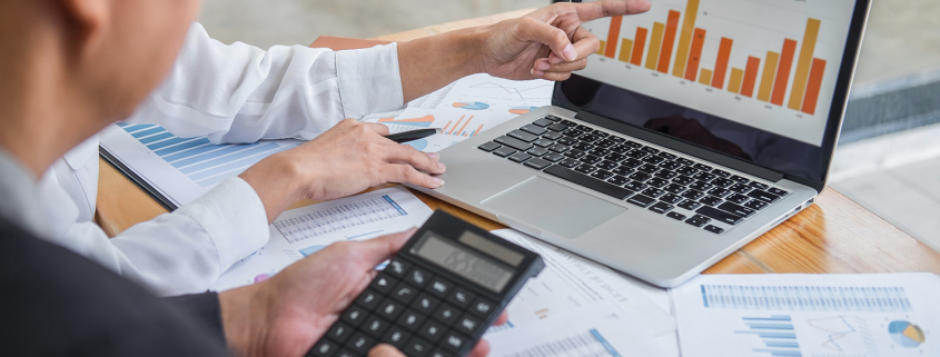 man in office with laptop and graphs