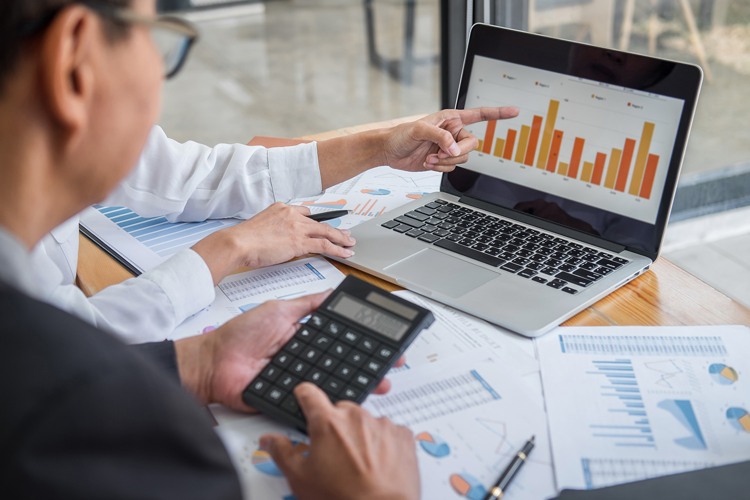man in office with laptop and graphs