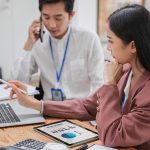 Cost of Outsourcing Payroll in the UK: A Guide two payroll professionals working